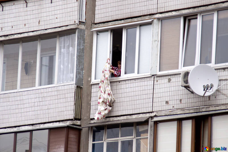 Жінка витрушує з вікна білизна №8752
