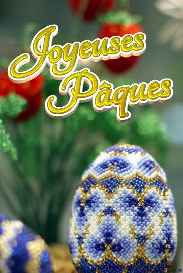 Joyeuses Pâques Easter egg decorated with beads on the background of flowers